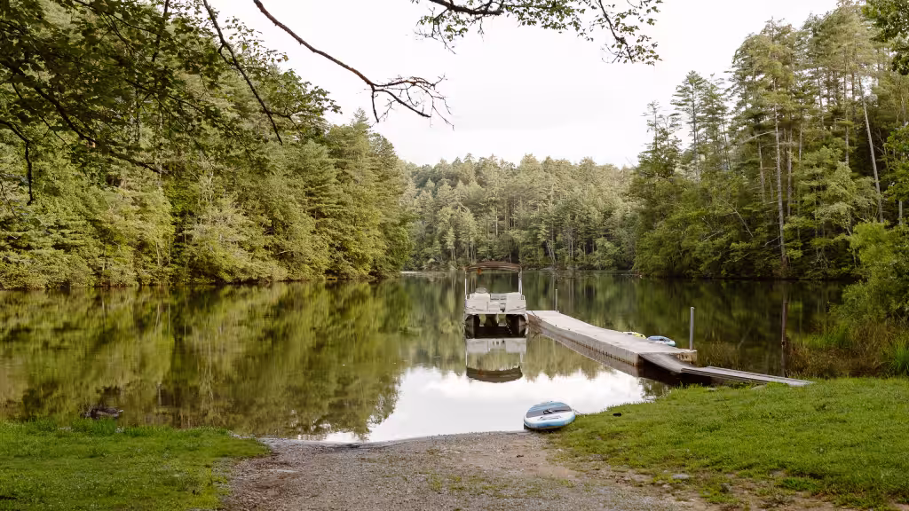 The dock reaching into Lake Santeetlah, forest down to the waterline on both sides