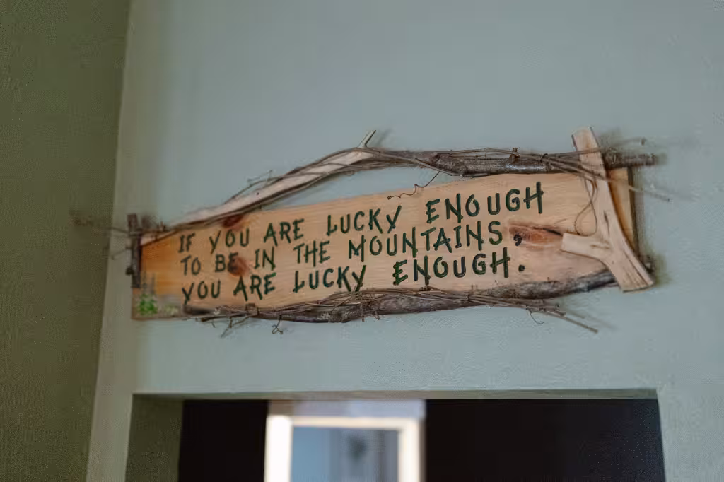 A hand-lettered wooden sign: If you are lucky enough to be in the mountains, you are lucky enough